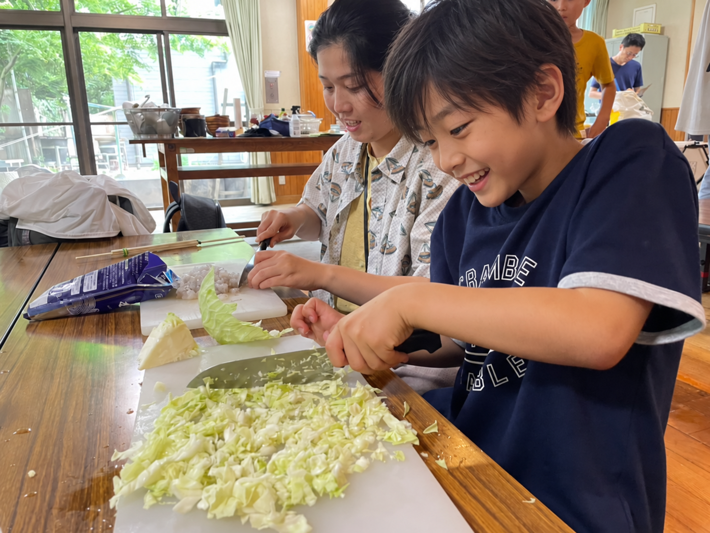 キャベツを切って料理を楽しむ様子。男の子の顔と髪型をAIで変更したイメージ。