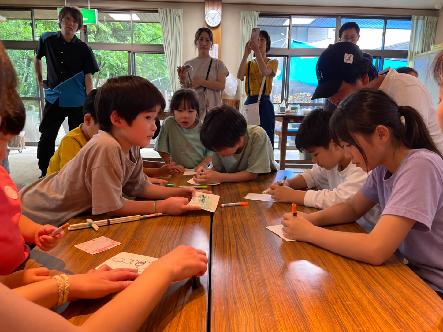 机を囲んで制作を楽しむ子どもたち。一部の人物をAIで加工したイメージ。