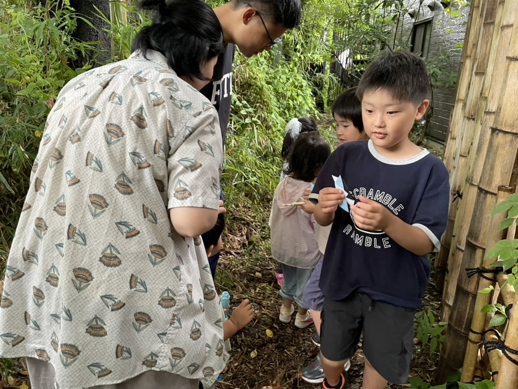 緑に囲まれた小道で、大人と子どもが一緒に過ごす様子。