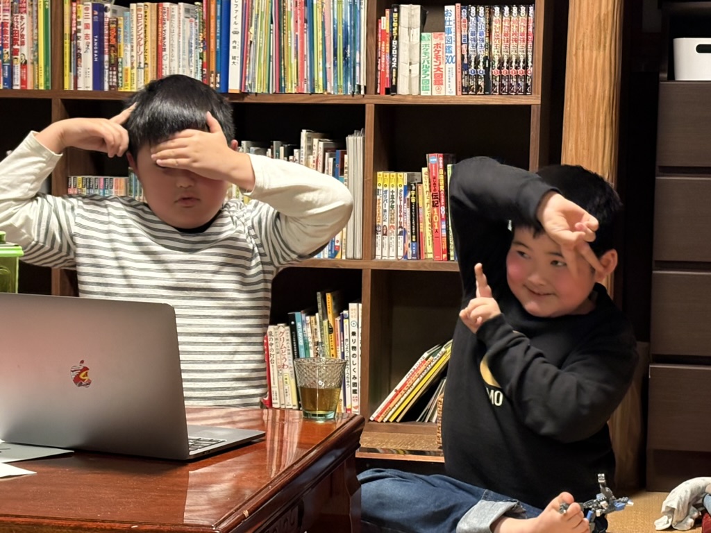 本棚のある部屋で、思い思いのポーズをする子どもたち。